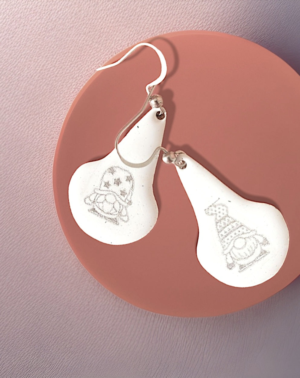 boucles d'oreilles en email sur cuivre en forme de goutte avec un petit personnage mignon noir sur fond blanc maison calub photo sur fond contrasté
