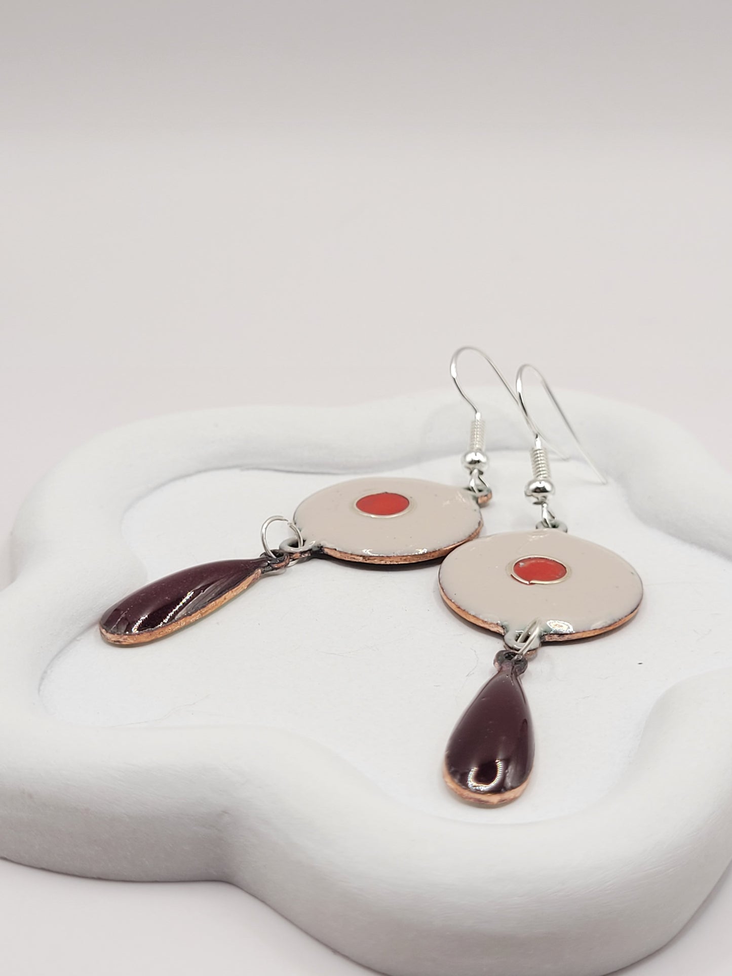 gros plan sur les boucles d'oreilles double rouge vif et rouge profond en email sur cuivre chez maison Calub