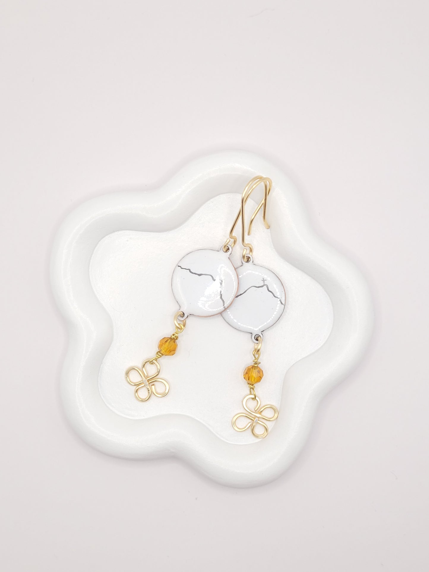 boucles d'oreilles en émail sur cuivre - bijou artisanal français évoquant la silhouette de la montagne sainte victoire à Aix-en-Provence, d'une simple ligne noire sur fond blanc.
