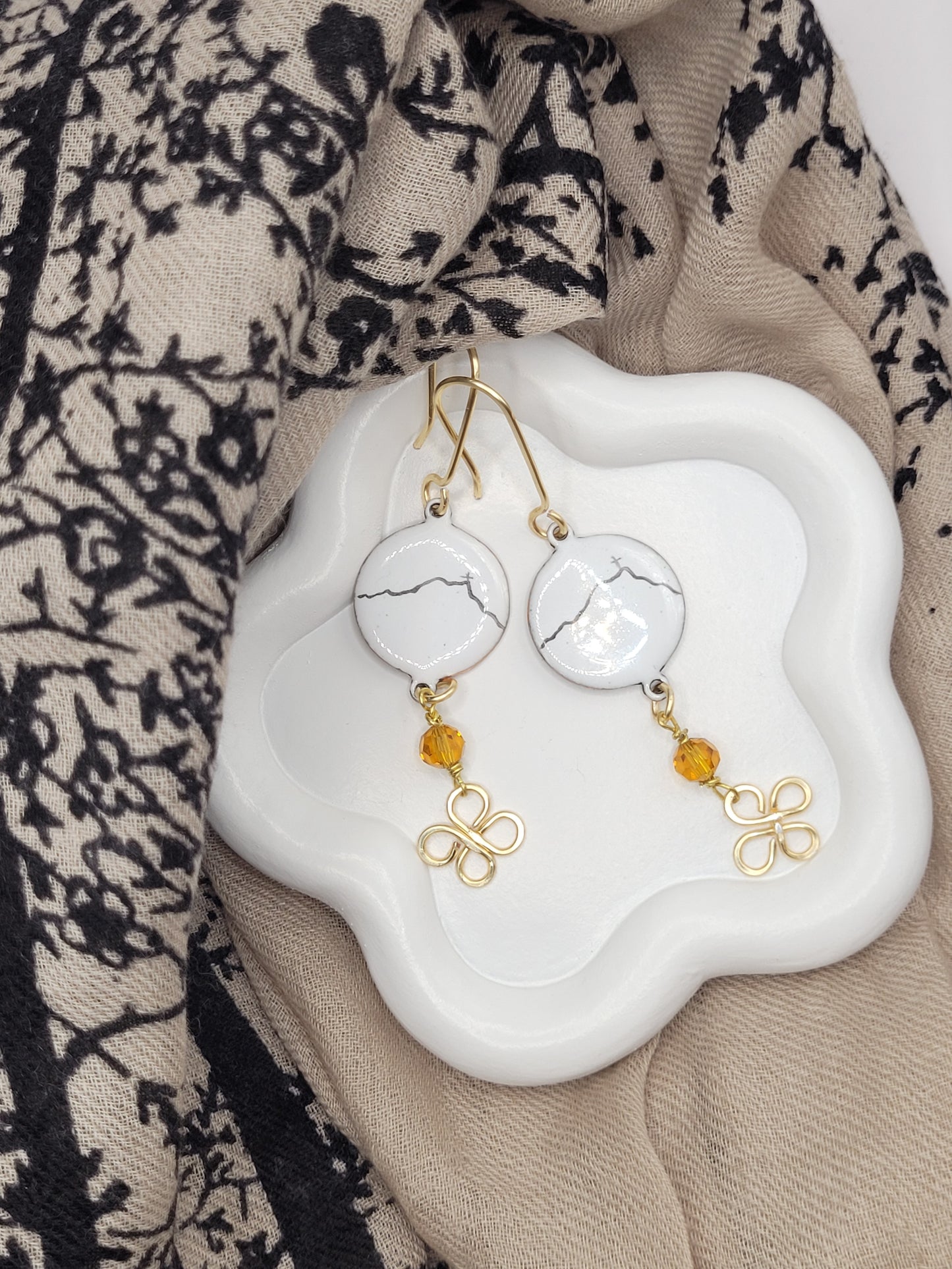 boucles d'oreilles Sainte-Victoire doré en émail sur cuivre - bijou artisanal français évoquant la silhouette de la montagne sainte victoire à Aix-en-Provence, d'une simple ligne noire sur fond blanc. aison CALUB