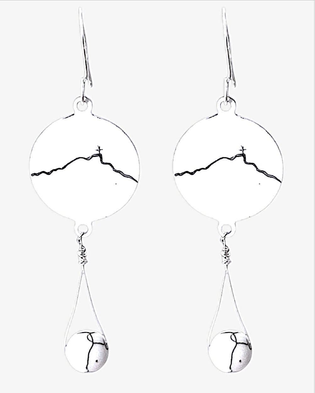 boucles d'oreilles en émail sur cuivre blanche, ornées de la ligne noire évoquant la montagne sainte-victoire à Aix en Provence. Création maison Calub.