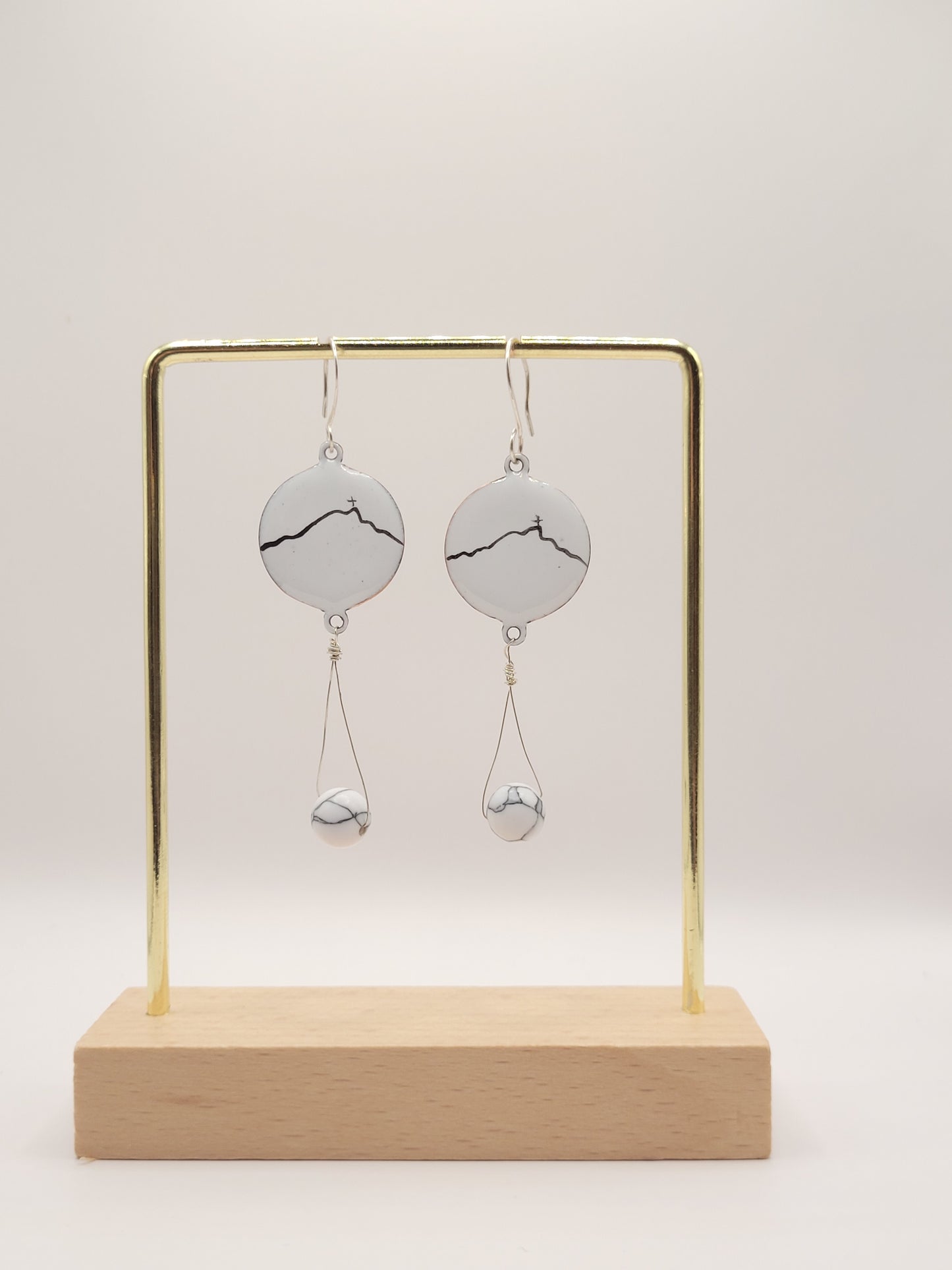 boucles d'oreilles en émail sur cuivre blanche, ornées de la ligne noire évoquant la montagne sainte-victoire à Aix en Provence. Création maison Calub.
