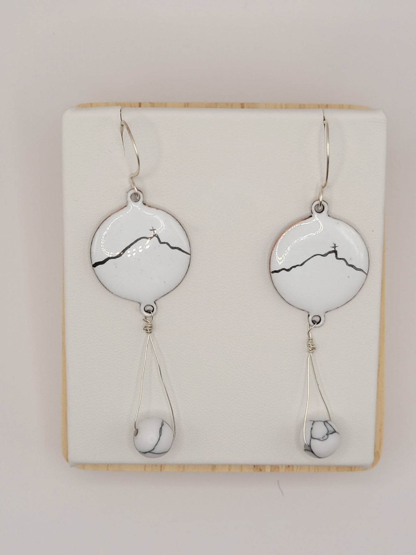 boucles d'oreilles en émail sur cuivre blanche, ornées de la ligne noire évoquant la montagne sainte-victoire à Aix en Provence. Création maison Calub.