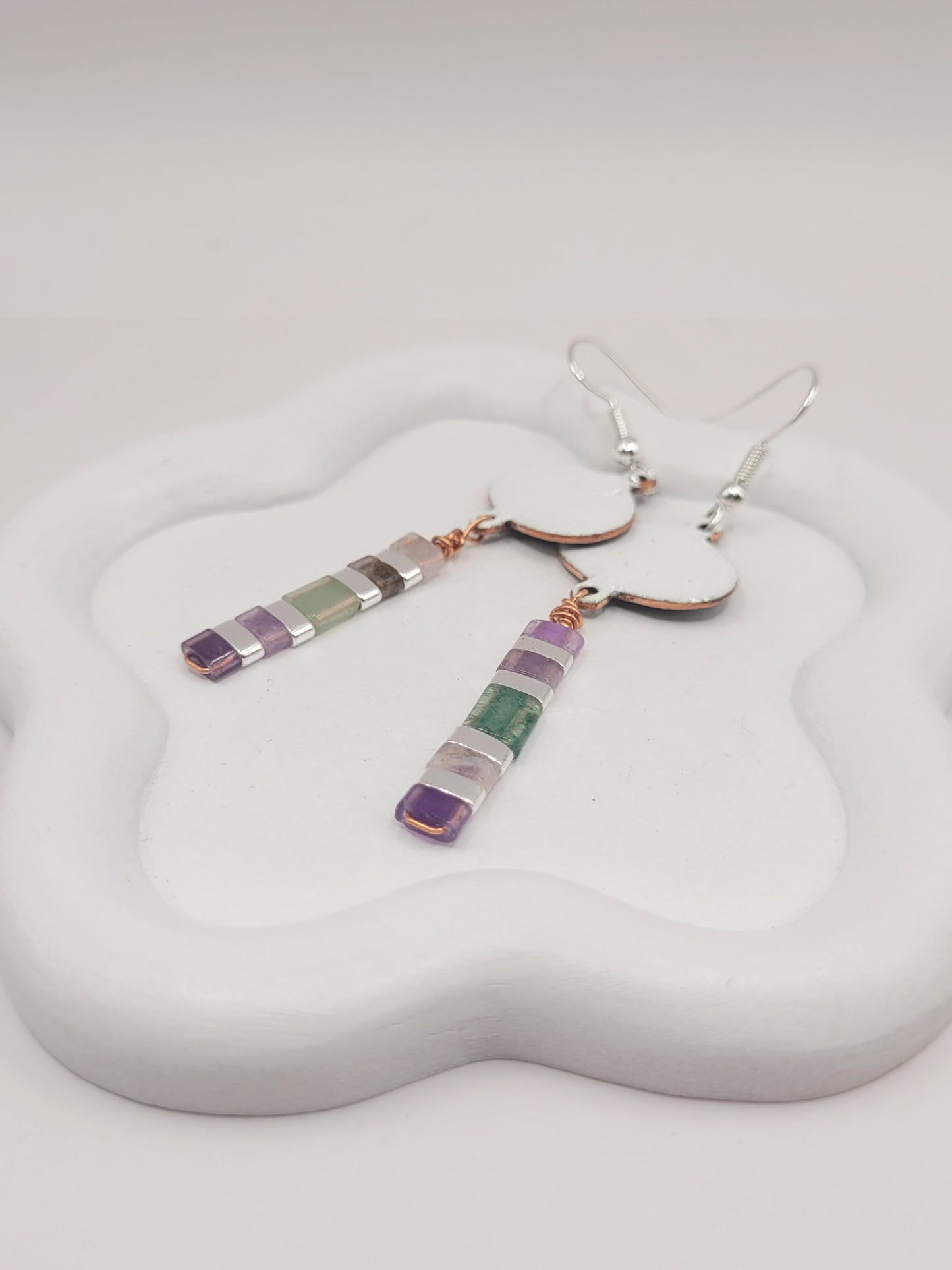 gros plan sur les boucles d'oreilles longues pendant emaux de la maison CALUB, bijou en email avec perles miyuki