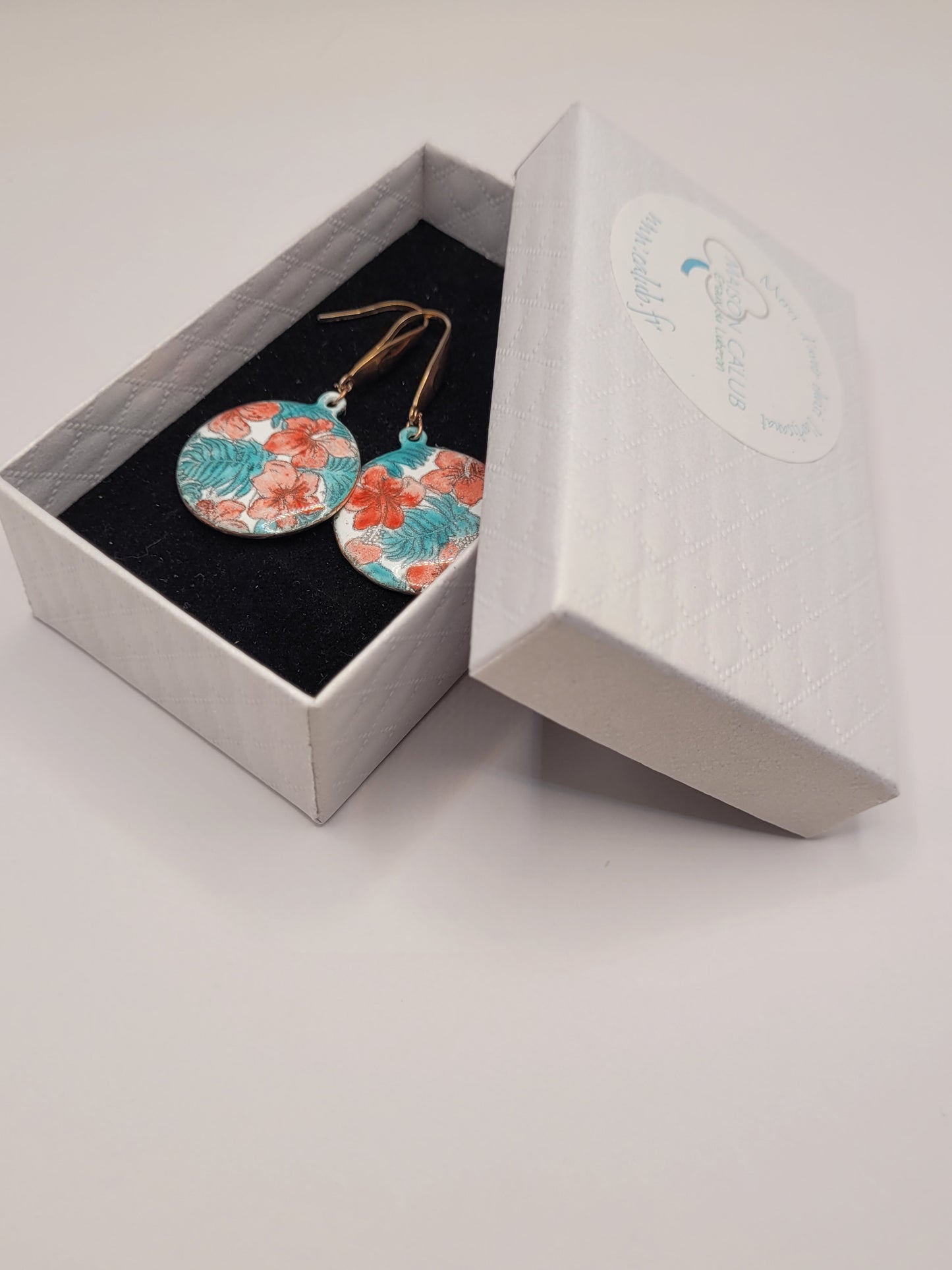Boucles d'oreilles en émail sur cuivre peint à la main, aux motifs rouges et vert inspiré des tissus Liberty, chez maison CALUB les émaux du Luberon. Présentation avec une petite boite cadeau