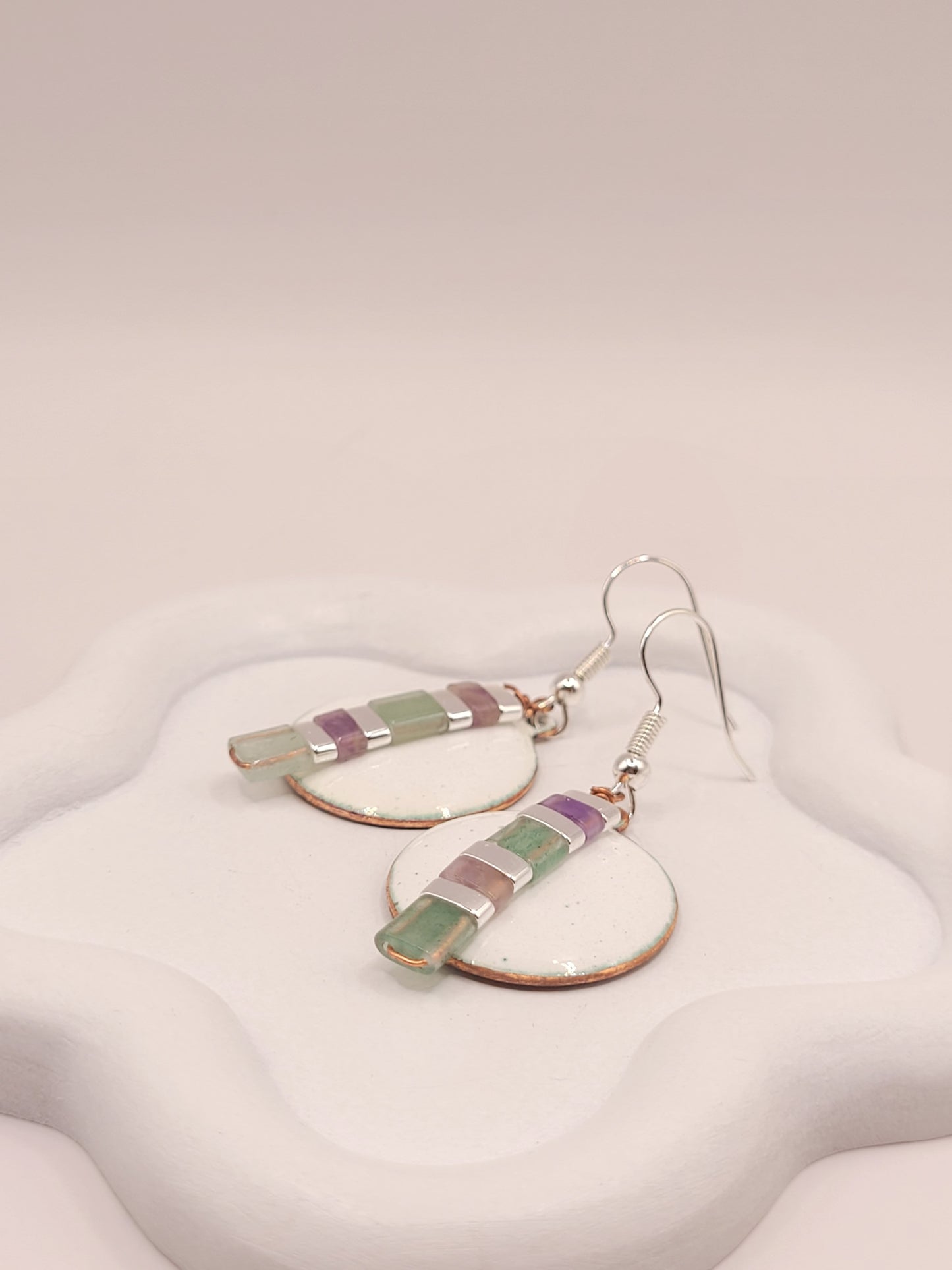 gros plan sur les boucles d'oreilles rondes pendant emaux de la maison CALUB, bijou en email avec perles miyuki
