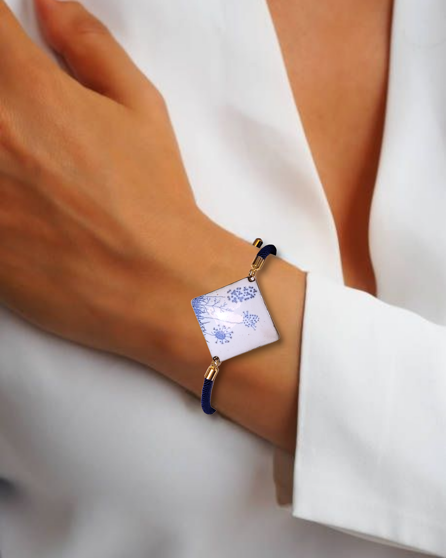 Bracelet cordon marine en émail sur cuivre de forme carrée. Les motifs bleus sur un émail blanc porcelaine dans la collection Les Uniques chez Maison Calub.