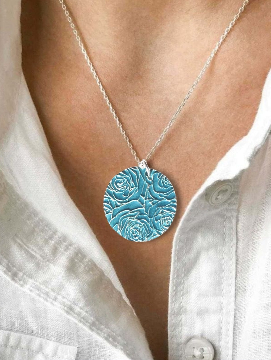 decolleté avec le pendentif bouquet de roses en champlevé émail sur argent fin turquoise. Bijou artisanal made in France chez maison calub les émaux du Luberon cadeau original