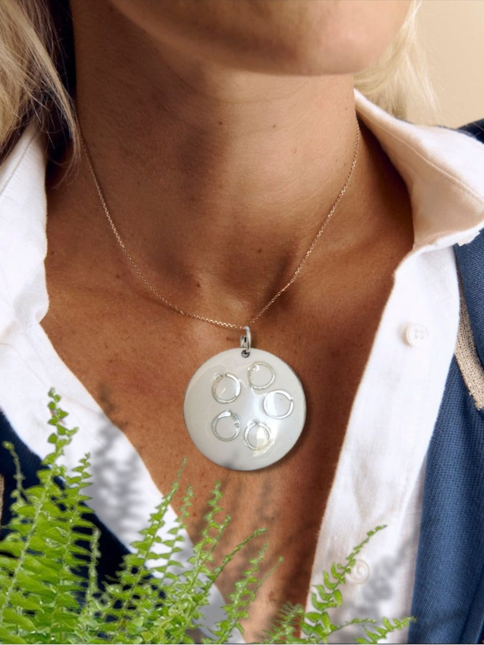 pendentif rond en email sur cuivre avec des anneaux en argent incrustés chez maison calub design contemporain decolleté