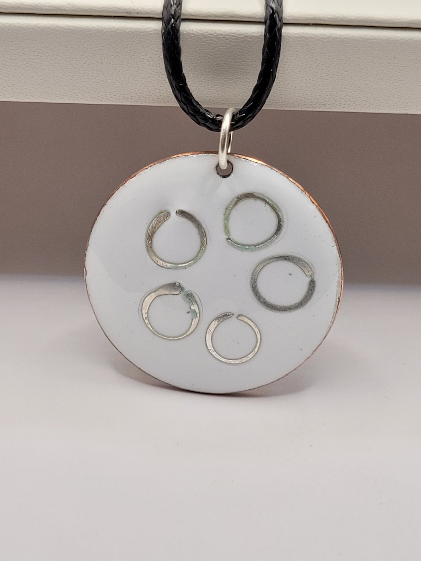 pendentif rond en email sur cuivre avec des anneaux en argent incrustés chez maison calub design contemporain presentoir