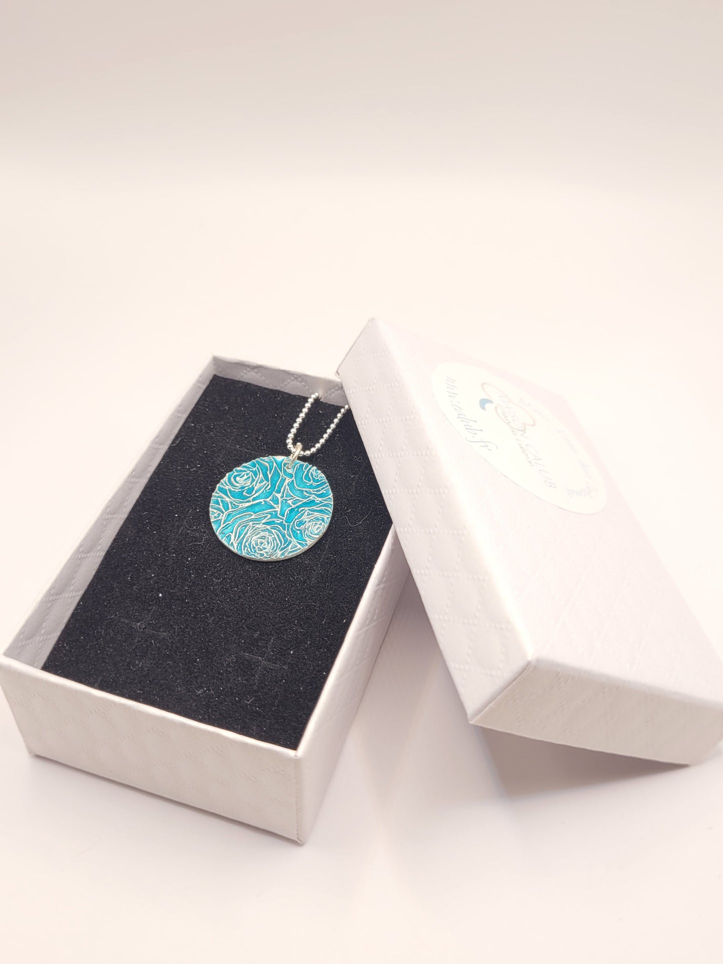dans sa boite cadeau le pendentif bouquet de roses en champlevé émail sur argent fin turquoise. Bijou artisanal made in France chez maison calub les émaux du Luberon cadeau original