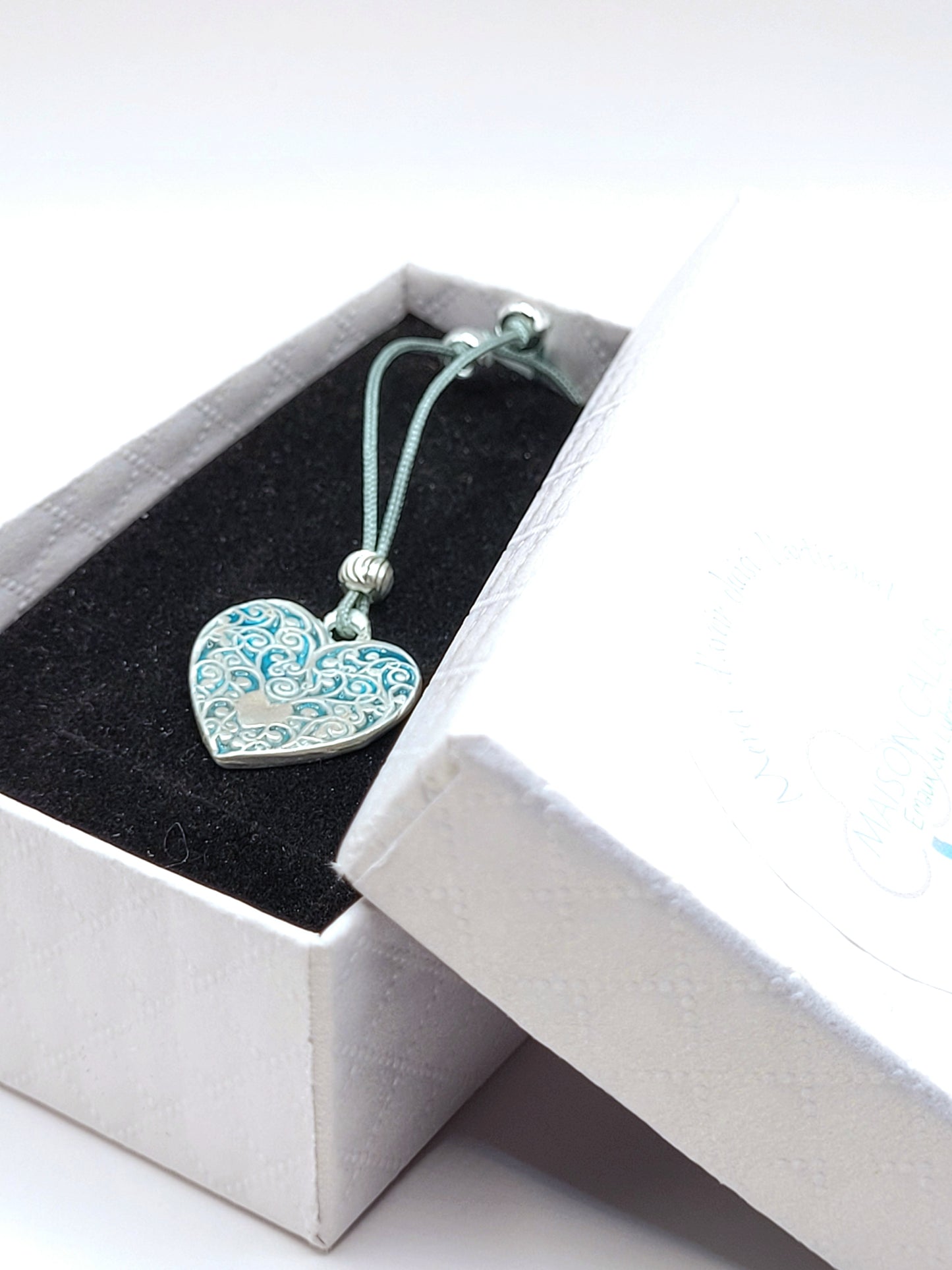 dans sa boite cadeau le petit pendentif en émail sur argent fin champelevé et émaux bleus. Bijou artisanal réalisé à la main dans l'ateiler maison calub les émaux du Luberon