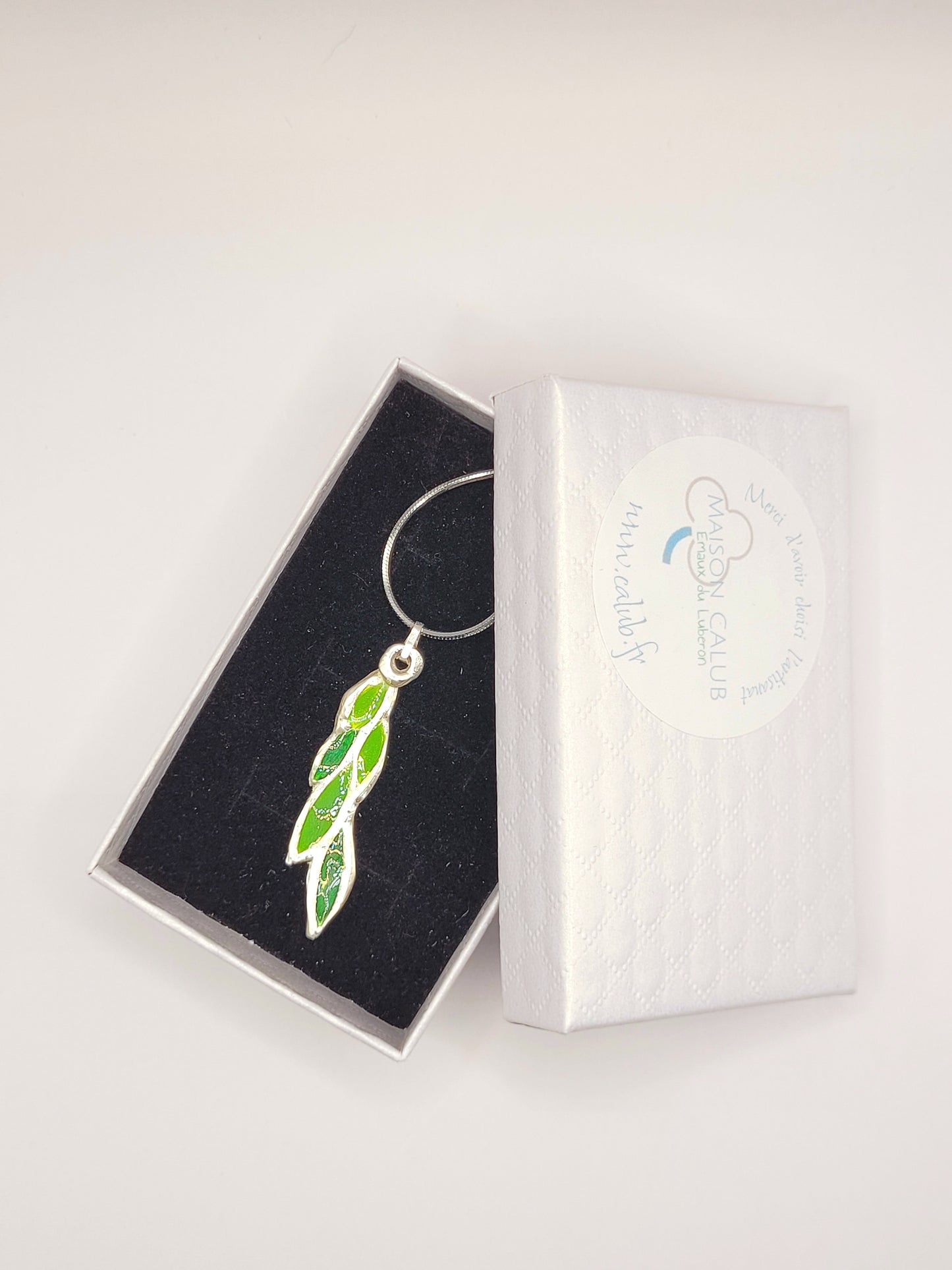 dans sa boite cadeau le pendentif léger en émail sur cuivre champlevé forme branche de laurier couleur verte 2 tons. Bijou artisanal émaux translucides chez maison calub les émaux du Luberon