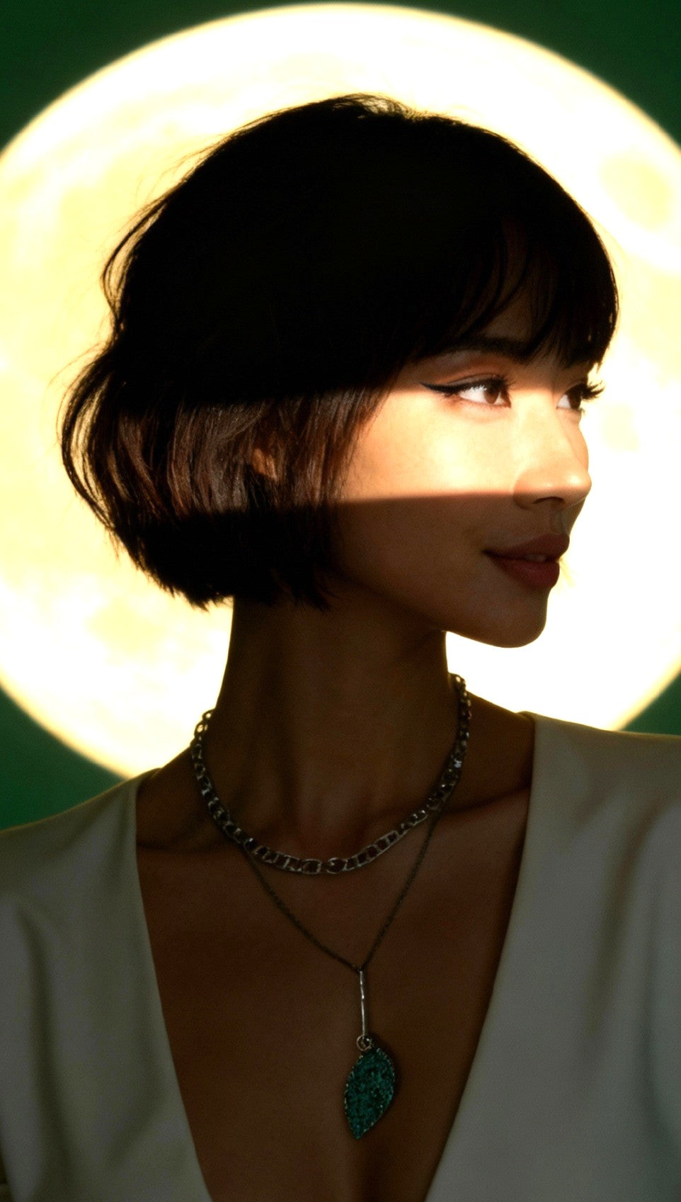 femme portant un pendentif en email grand feu vert motif de feuille sur argent fin - bijou artisanal maison calub