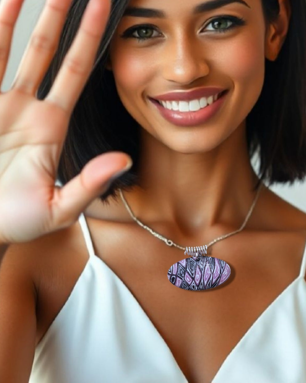 jeune femme élégante porte le pendentif ovale au design original inspiré par la lavande de provence chez maison calub émail sur cuivre opaque finition givrée mate émaux traditionnels fait à la main en provence belière en argent monté sur cordon