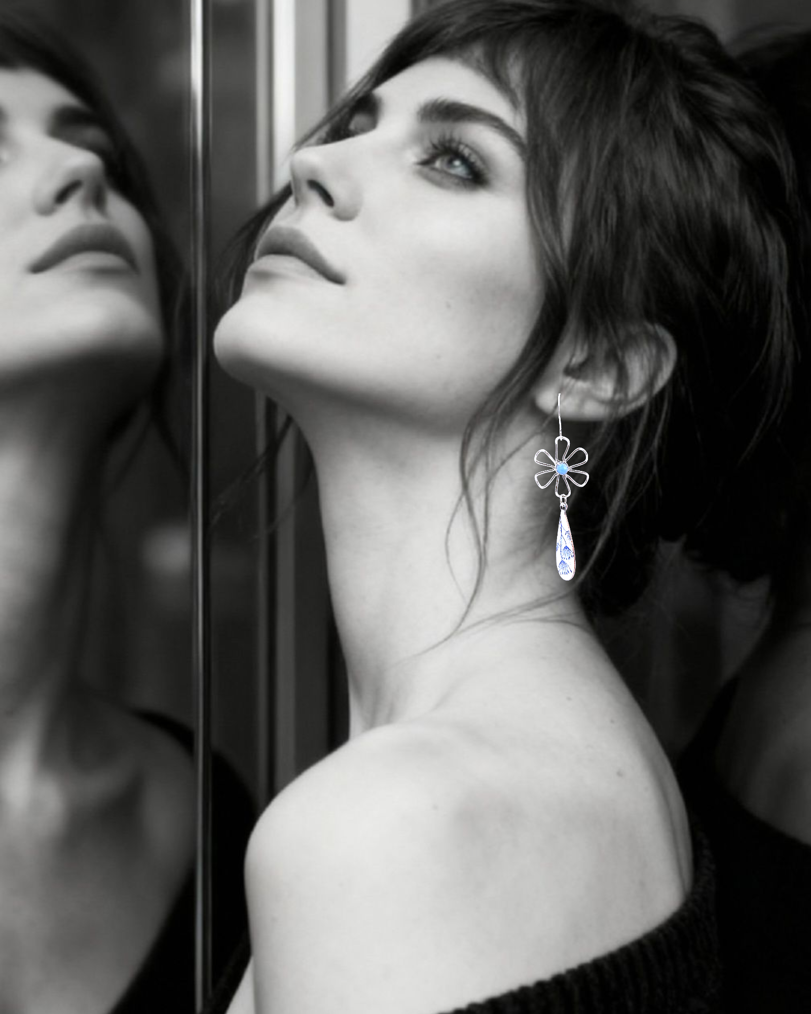 femme protant les boucles d'oreilles effet porcelaine bijou artisanal fait main, boucles d'oreilles pendantes en émail sur cuivre et argent, aux allure de porcelaine aux motif floraux bleus. Création originale Maison calub