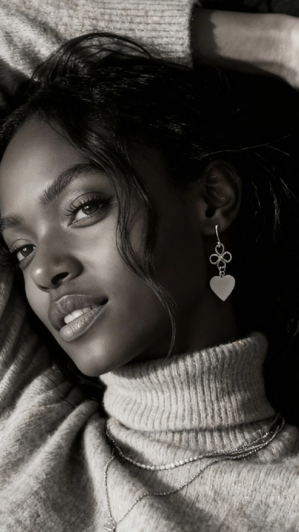 femme port un bijou artisanal fait main, boucles d'oreilles coeur en émail  blanc montage sur laiton doré. Création artisanale de maison calub. Emaux opaques