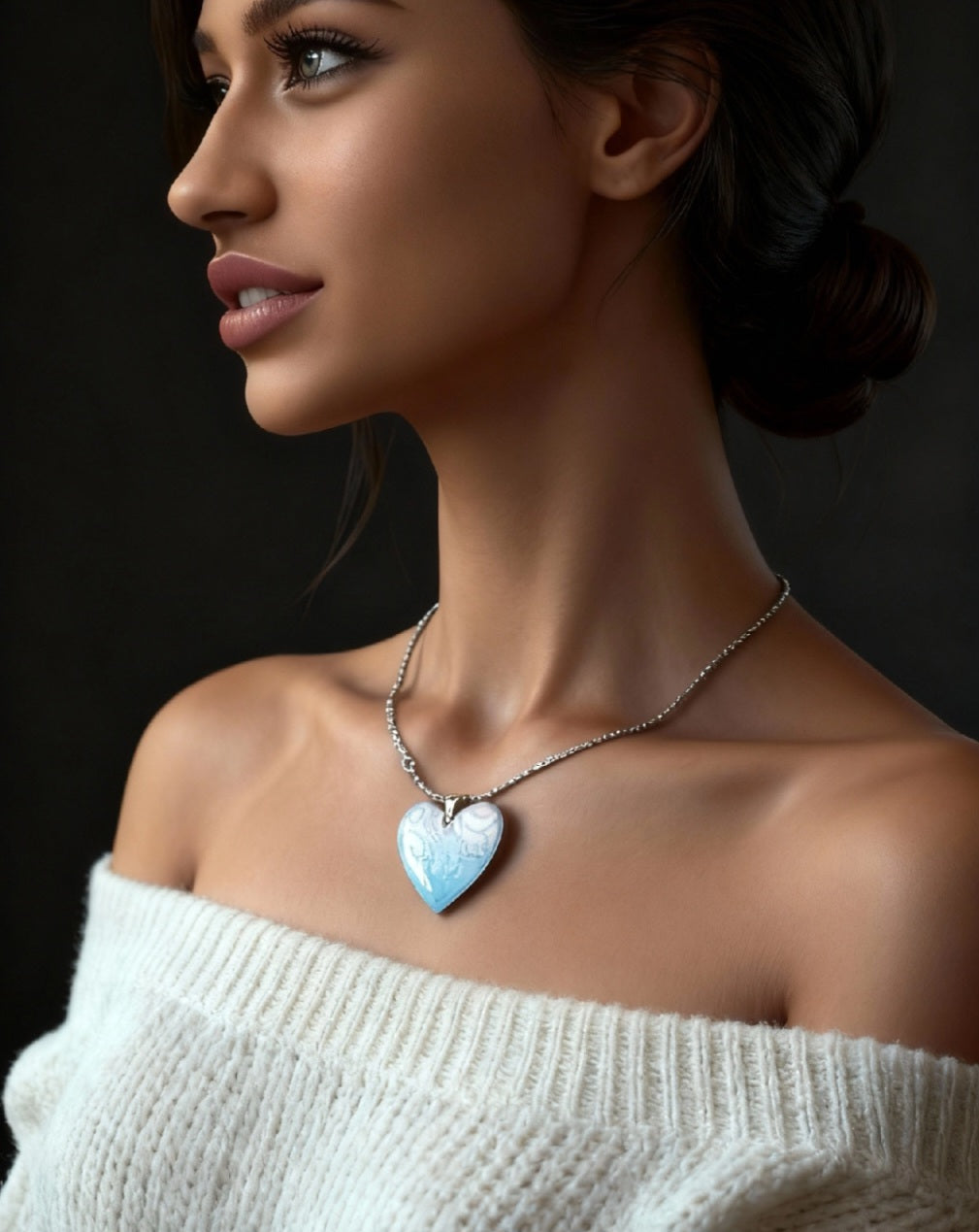 femme portant un pendentif en émail forme de coeur aux motifs  fins de couleur bleue. Emaux opaques et transparents - création maison calub - idéal cadeau original femme