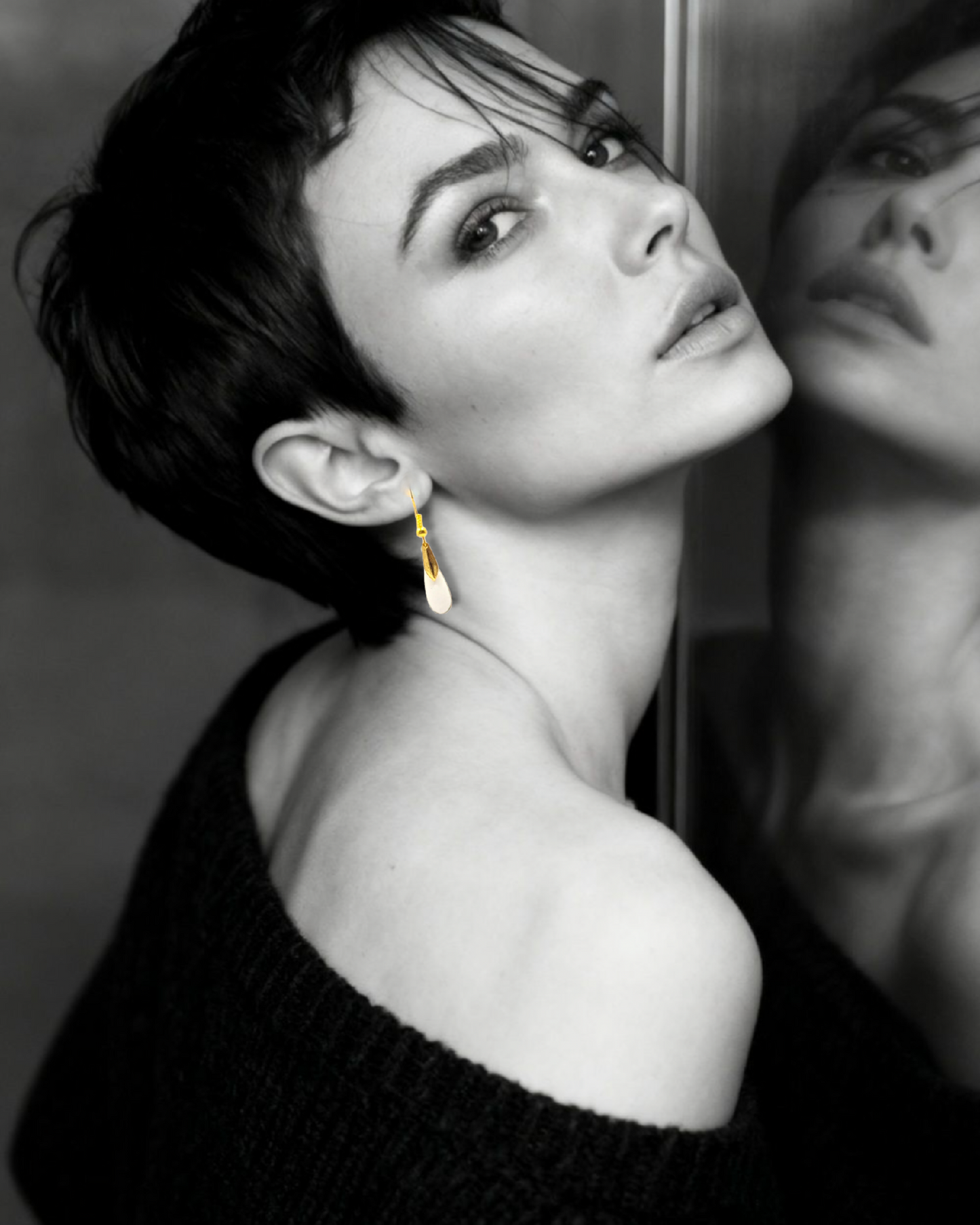 bijou artisanal boucles d'oreilles en email blanc et agrémentées d'une petite feuille dorée très simples et légères création maison Calub. Femme brune