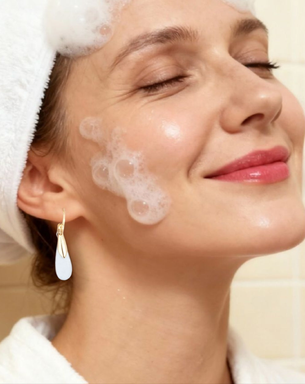 bijou artisanal boucles d'oreilles en email blanc et agrémentées d'une petite feuille dorée très simples et légères création maison Calub. Femme fait sa toilette