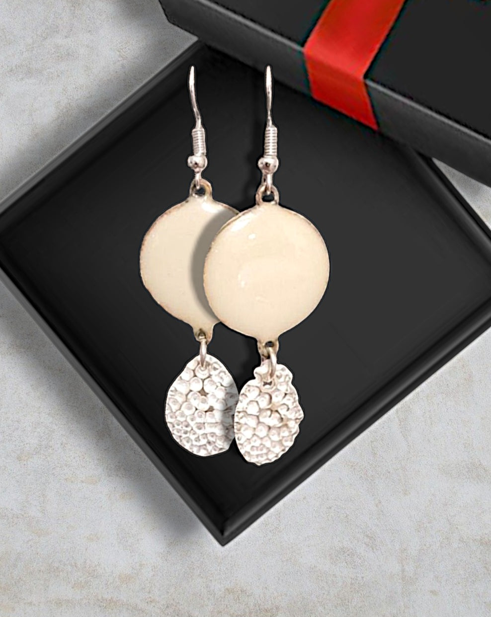 bijou artisanal chic pour ces boucles d'oreilles en émail sur cuivre ablanc crème avec une breloque d'argent fin pépite mobile de chez maison calub. Dans sa boite cadeau