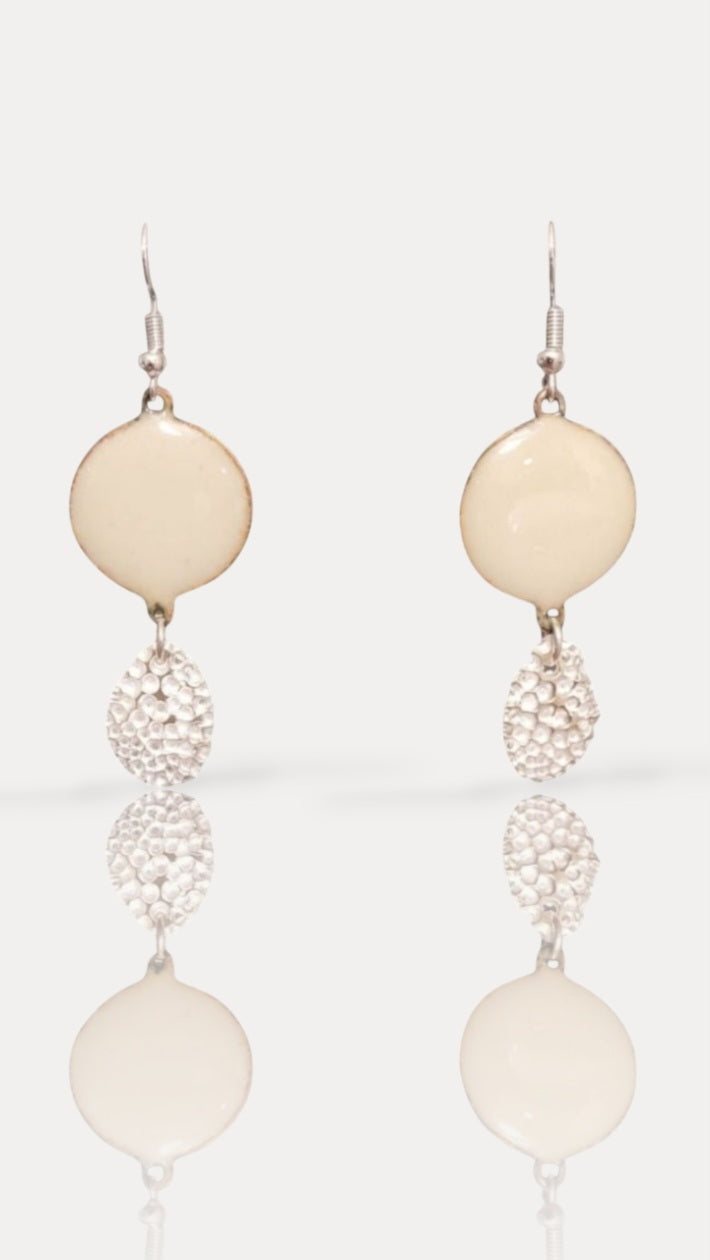 bijou artisanal chic pour ces boucles d'oreilles en émail sur cuivre ablanc crème avec une breloque d'argent fin pépite mobile de chez maison calub. sur fond blanc
