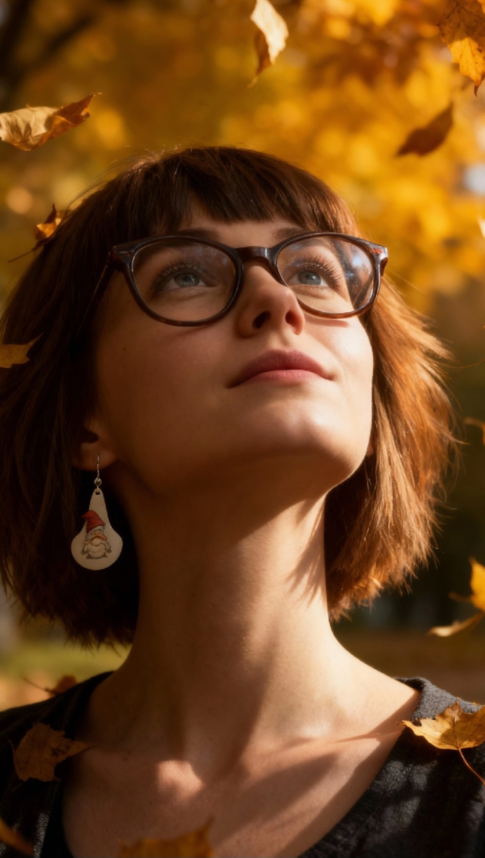 femme portant des boucles d'oreilles en email sur cuivre en forme de goutte avec un petit personnage mignon noir sur fond blanc maison calub photo sur fond contrasté. Bijou artisanal
