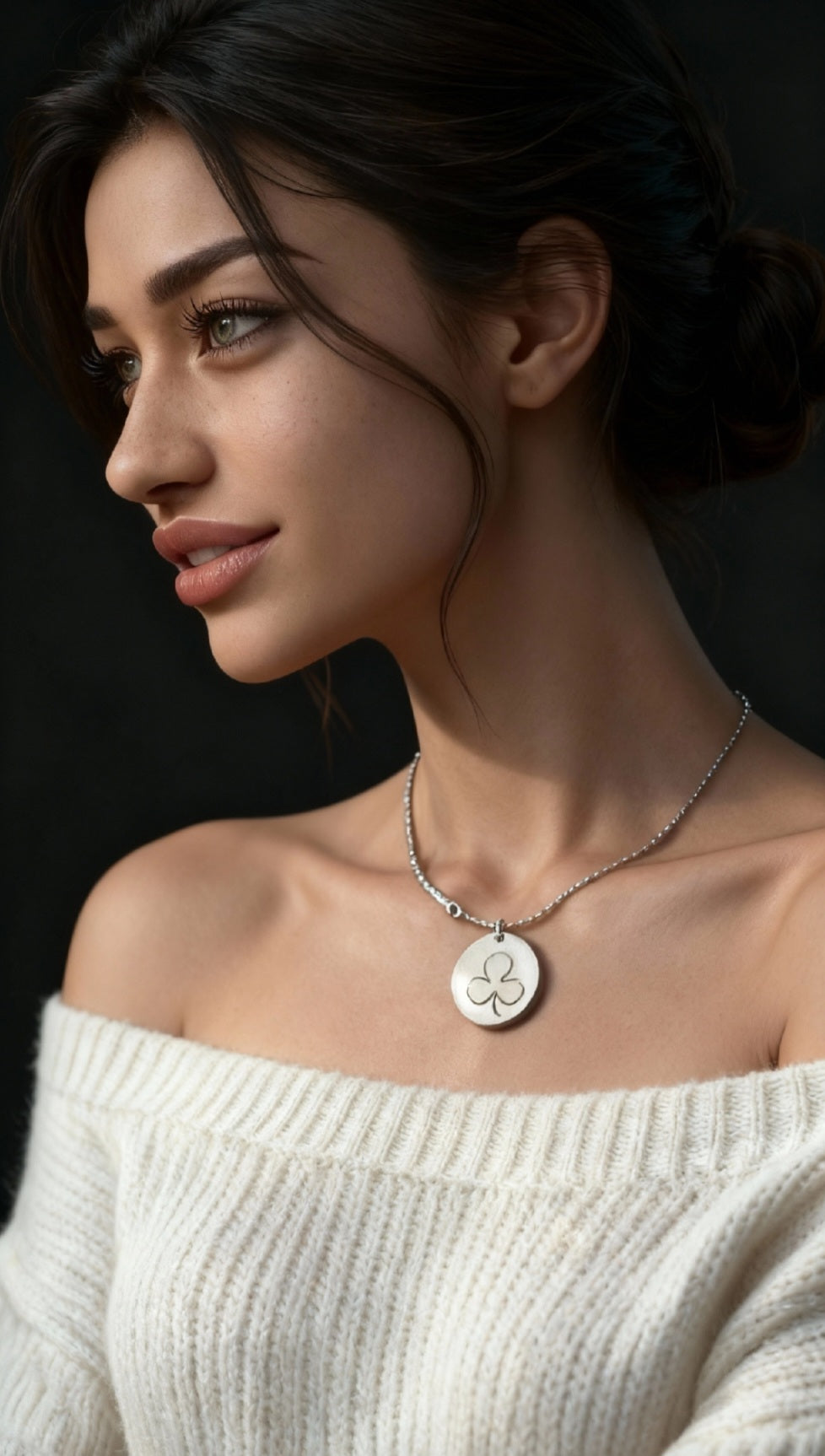 une jolie jeune femme porte le pendentif en email sur cuivre emblème de maison calub simple trèfle en argent fin sur émaux crème effet céramique. Création artisanale