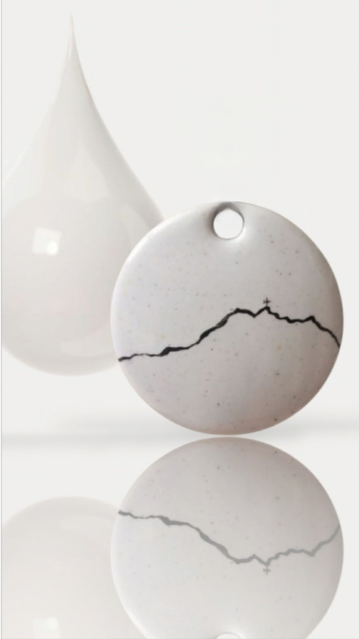 bijou artisanal fait main, grand pendentif en émail blanc avec une ligne noire représentant le profil de la montagne Sainte-Victoire. Création originale Maison calub. Fond blanc