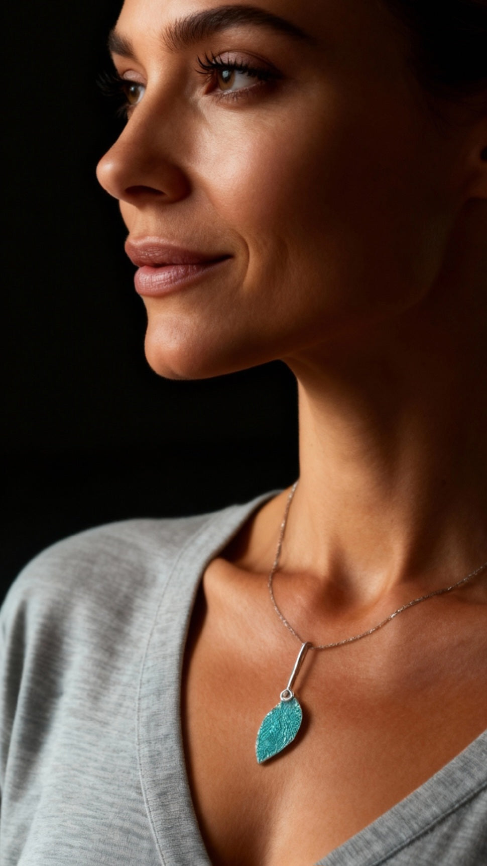 femme portant un pendentif en email grand feu vert motif de feuille sur argent fin - bijou artisanal maison calub -cadeau original femme