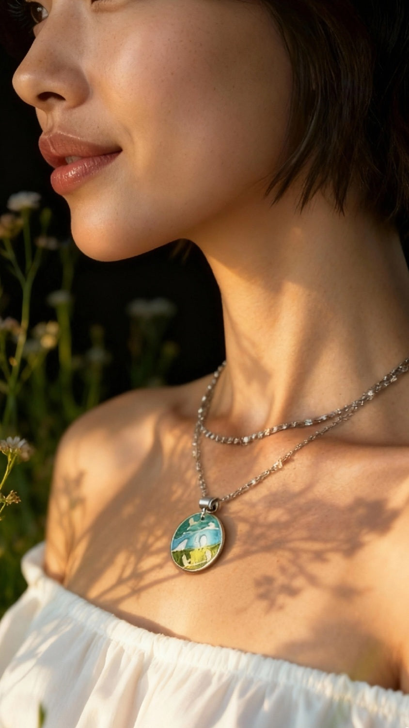 femme portant un pendentif champlevé en émail sur argent fin représentant des oiseaux dans les arbres. Emaux translucides. Bijou artisanal maison Calub les émaux du luberon made in France