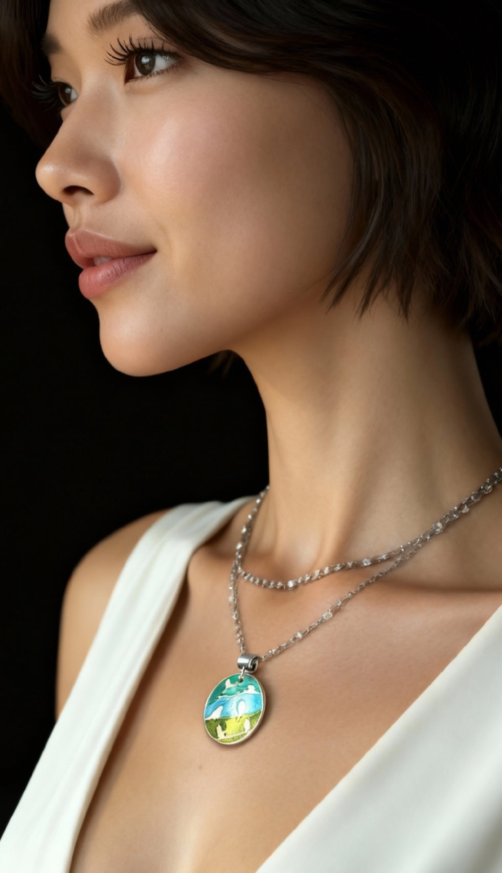 femme portant un pendentif champlevé en émail sur argent fin représentant des oiseaux dans les arbres. Emaux translucides. Bijou artisanal maison Calub les émaux du luberon made in France