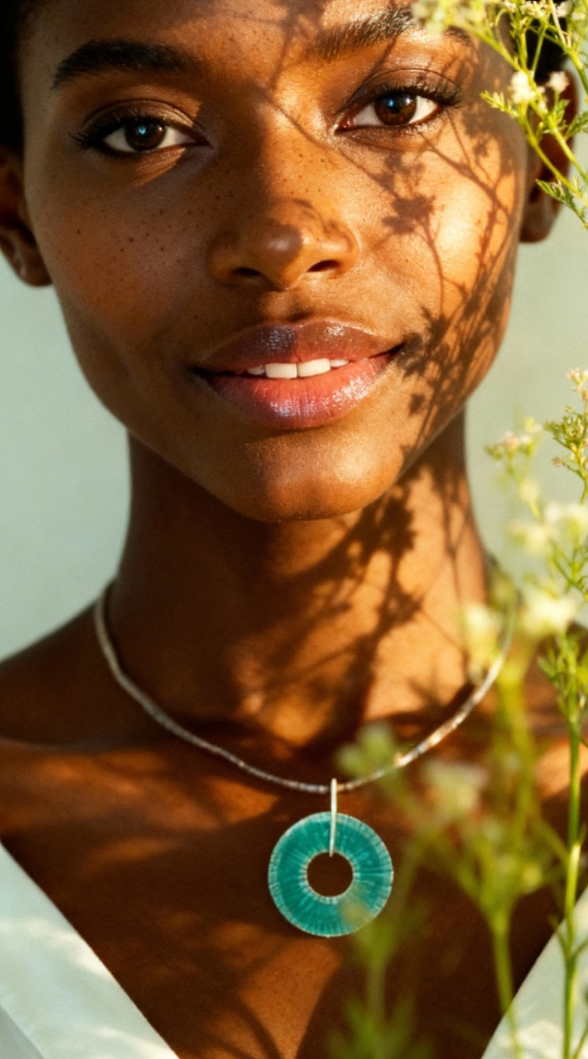 jeune femme avec un  pendentif ROUE émail basse-taille sur argent fin de couleur turquoise -  maison CALUB émaux du Luberon. bijou artisanal en émail grand feu.