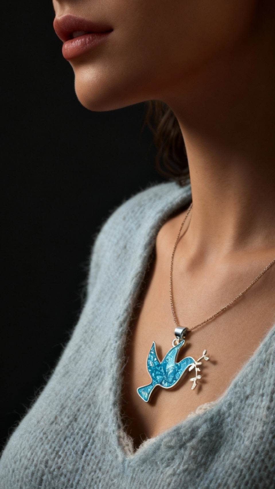 femme portant le Pendentif basse-taille en émail sur argent fin colombe de la paix contemporain. Bijou artisanal réalisé à la main chez maison Calub les émaux du Luberon. Email translucide bleu