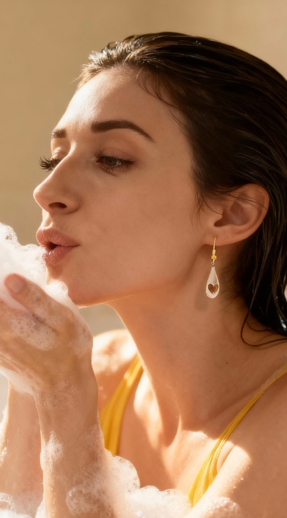 femme portant des petites boucles d'oreilles gouttes émaux blancs avec des petits coeurs de lustre d'or. bijou artisanal en émail, création maison calub.