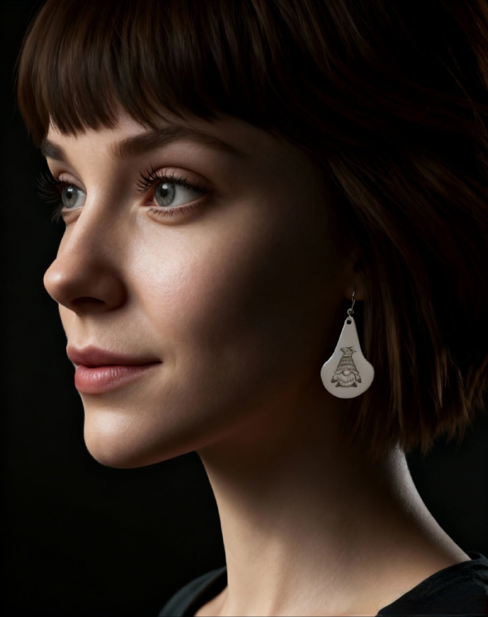 femme portant des boucles d'oreilles en email sur cuivre en forme de goutte avec un petit personnage mignon noir sur fond blanc maison calub photo sur fond contrasté. Bijou artisanal