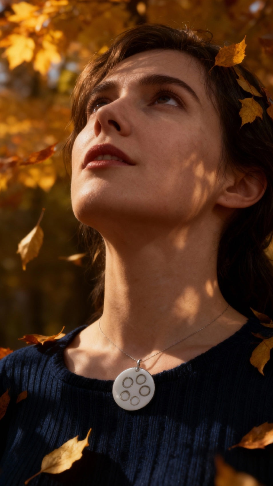 femme portant un pendentif rond en email sur cuivre avec des anneaux en argent incrustés chez maison calub design contemporain - bijou artisanal fait main