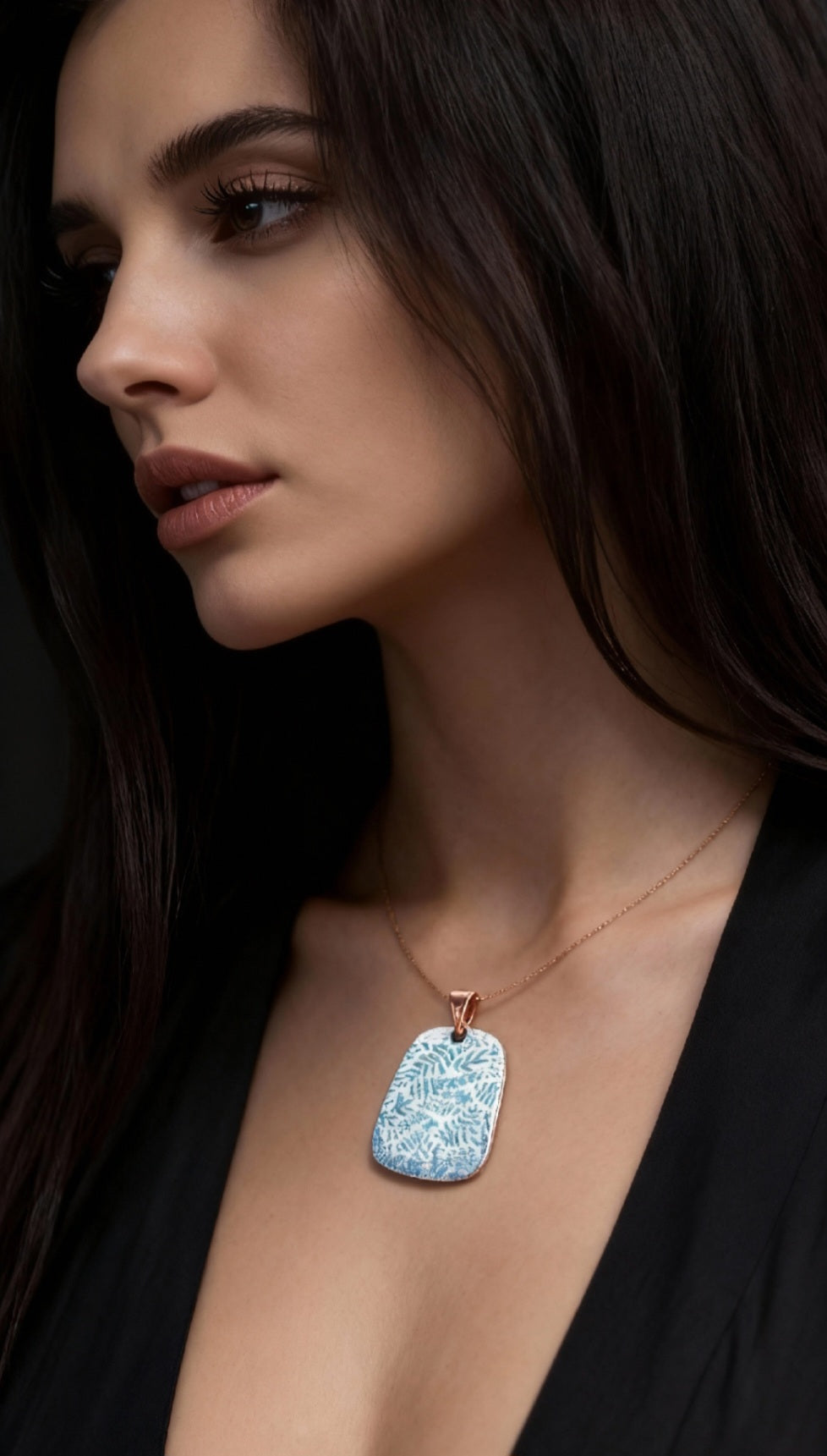 femme portant un bijou artisanal pendentif emaux sur cuivre peint à la main motif feuillage vert sur blanc creme de maison calub