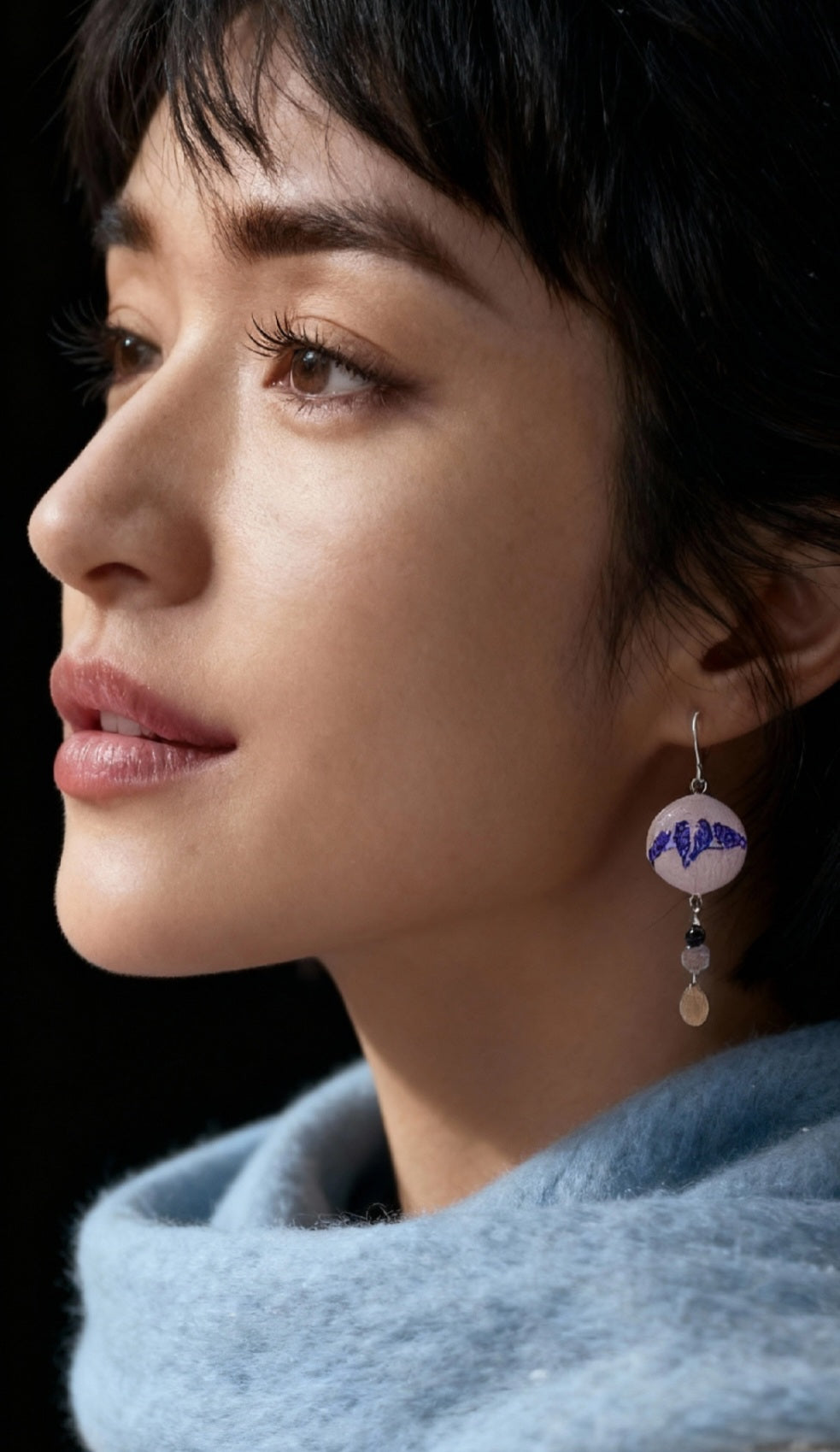 femme portant des  boucles d'oreilles en émail grand sur sur cuivre, aux motifs fins d'oiseaux, et prolongée par quelques pierres naturelles et breloque en argent