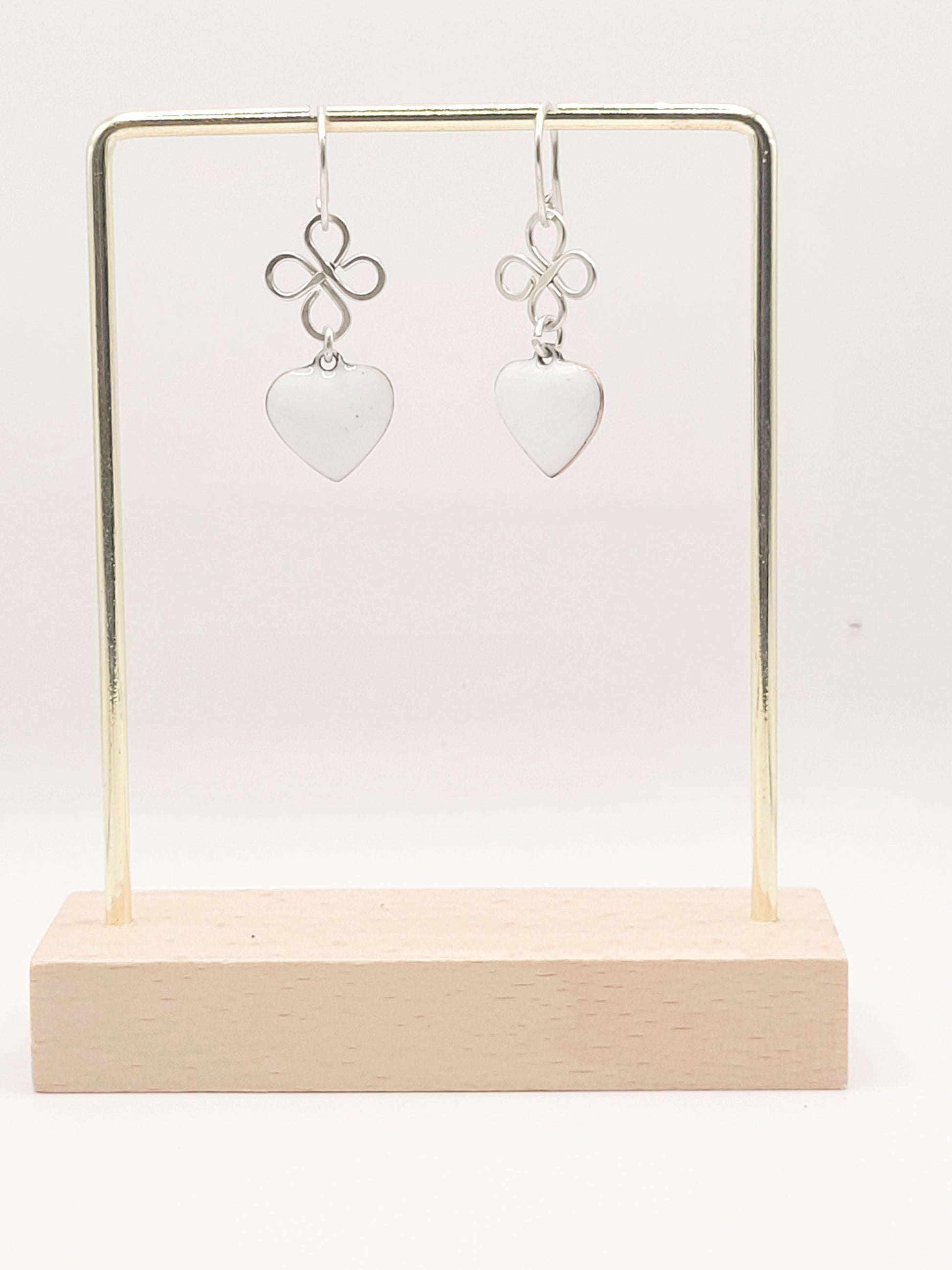 présentation des boucles d'oreilles coeur en émail  blanc montage sur argent. Création artisanale de maison calub. Emaux opaques