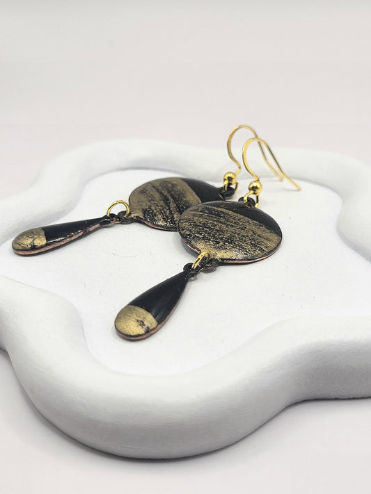 gros plan sur les boucles d'oreilles chic noir et doré double pendant email sur cuivre . Emaux traditionnels fait main chez maison calub