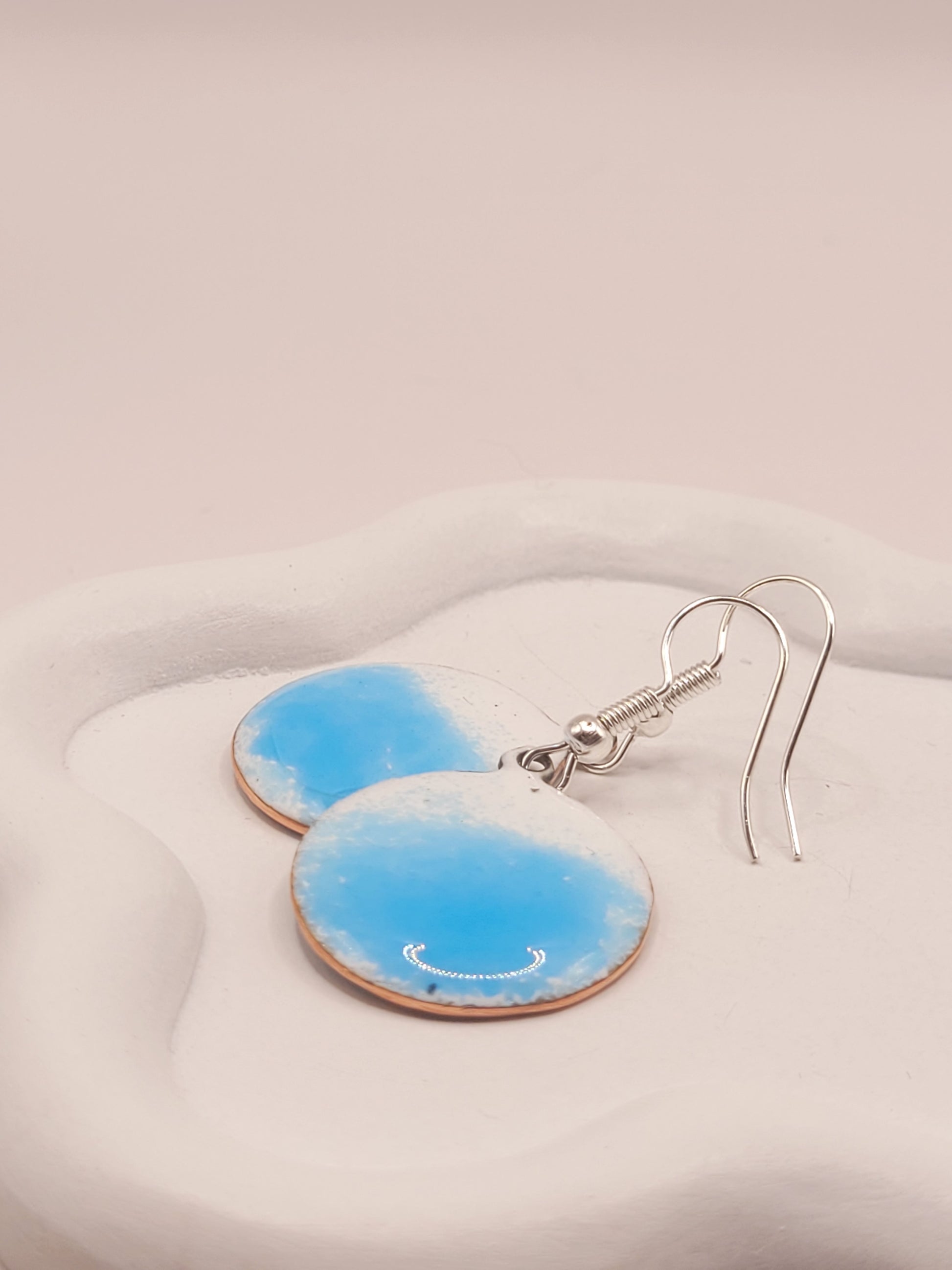 gros plan sur les boucles d'oreilles rondes oh bleu de maison calub pendant en émail sur cuivre bleu translucide sur fond blanc émaux traditionnels