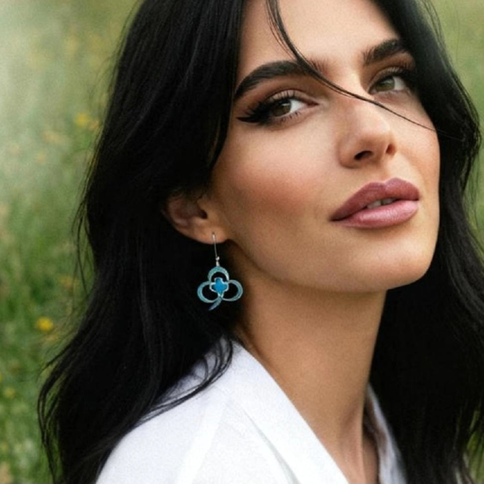 Bijou email artisanal trefle porté par une femme