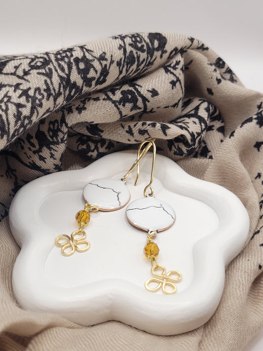 boucles d'oreilles en émail sur cuivre - bijou artisanal français évoquant la silhouette de la montagne sainte victoire à Aix-en-Provence, d'une simple ligne noire sur fond blanc.Breloque dorée et perle en verre