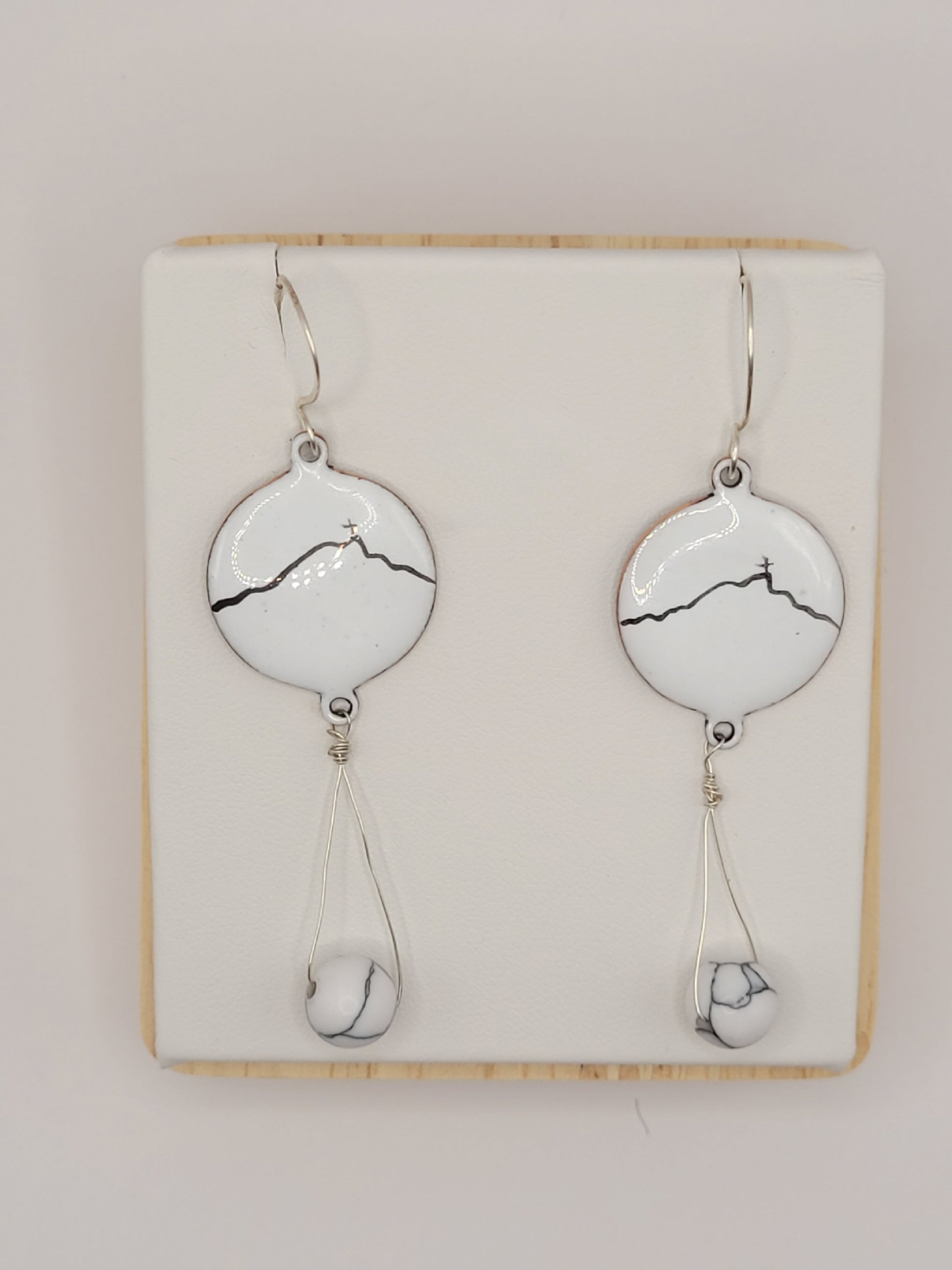 boucles d'oreilles en émail sur cuivre blanche, ornées de la ligne noire évoquant la montagne sainte-victoire à Aix en Provence. Création maison Calub.
