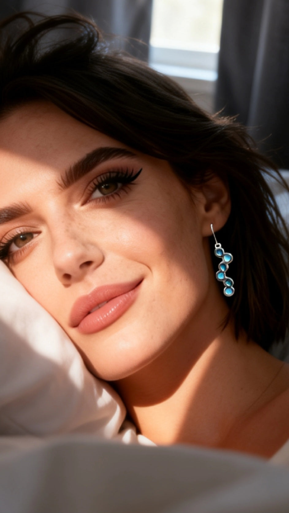 Boucles d'oreilles email argent portées par une femme, motif bulles bleu