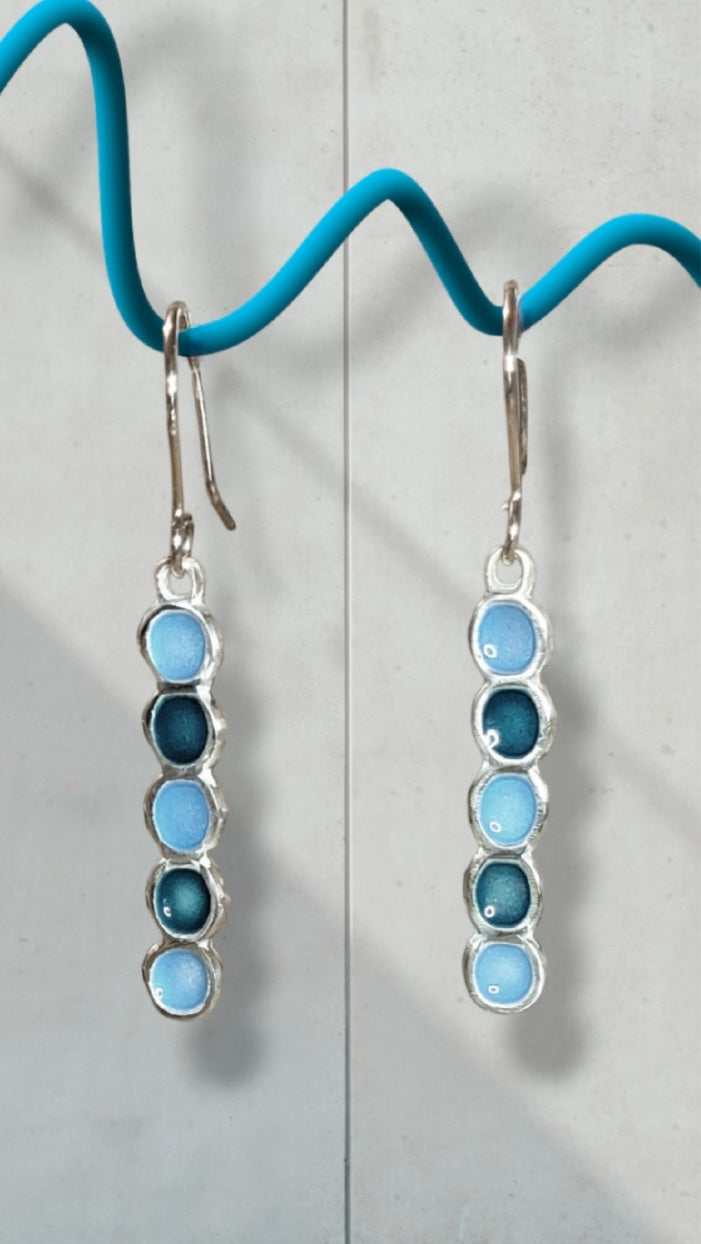 Boucles d'oreilles email argent portées par une femme, motif cercles bleu