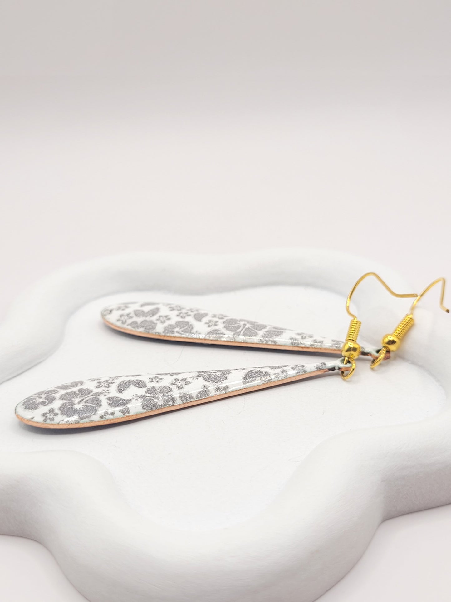 sur une soucoupe boucles d'oreilles en forme de longue goutte en email sur cuivre au motif floral - création artisanale maison calub