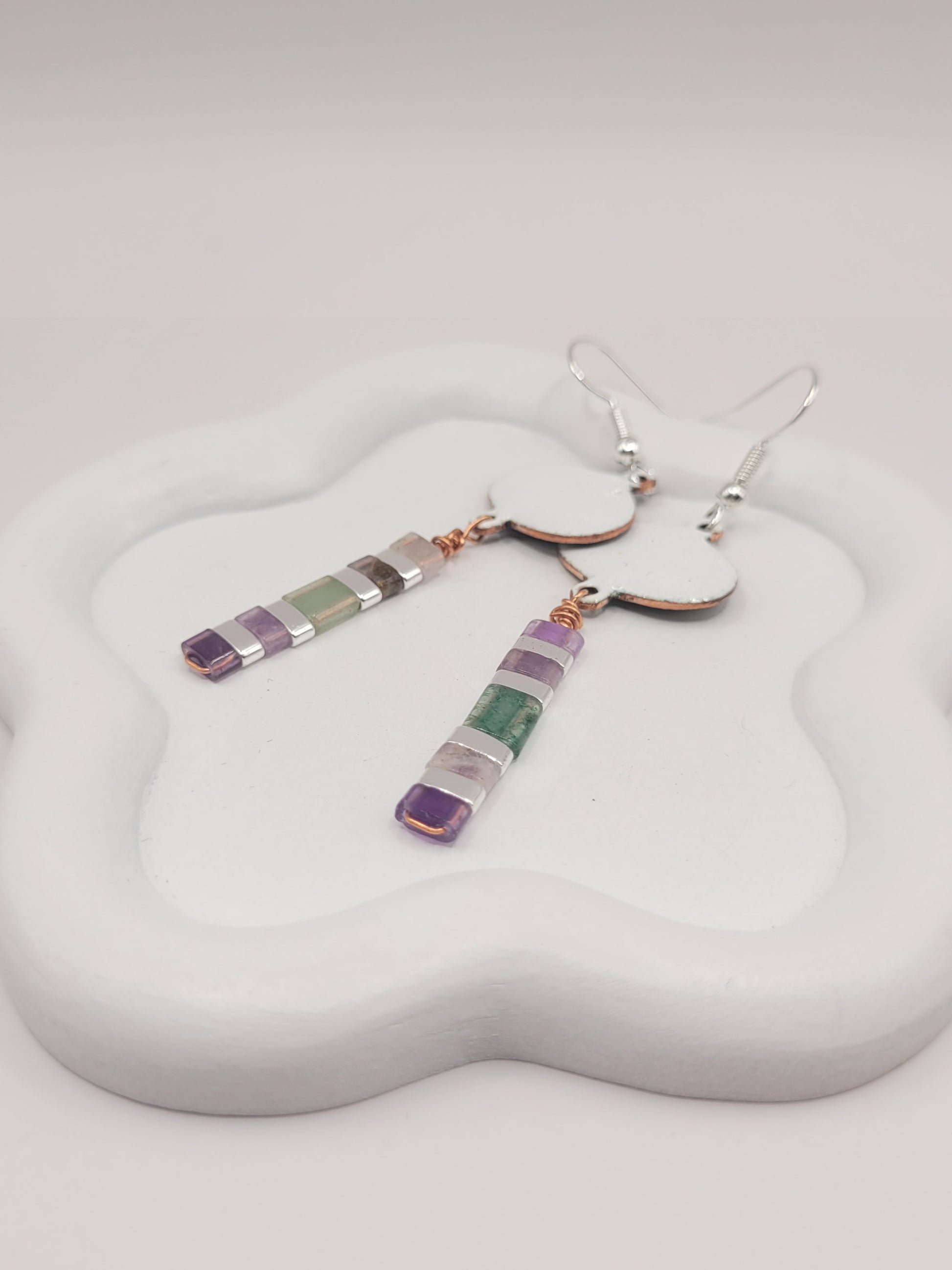 gros plan sur les boucles d'oreilles longues pendant emaux de la maison CALUB, bijou en email avec perles miyuki