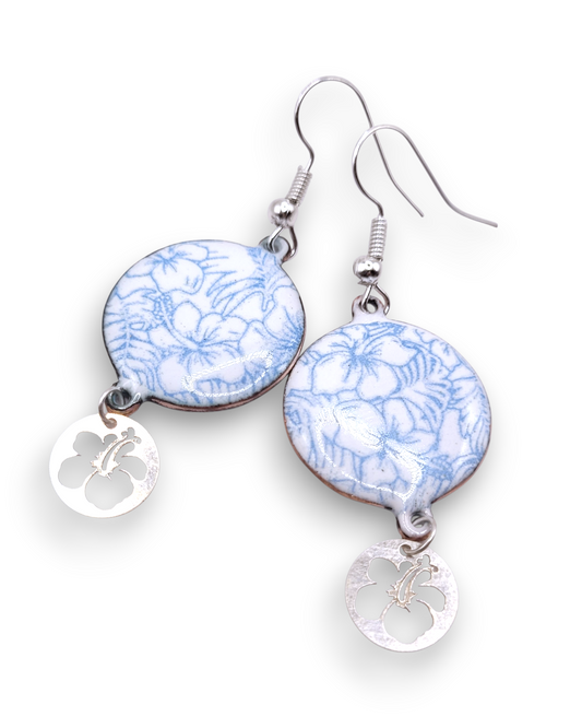 boucles d'oreilles en email sur cuivre aux motifs  floraux légers hibiscus  bleus prolongé par une breloque en argent hibiscus. Bijou artisanal émaillé à la main chez maison CALUB les émaux du Luberon